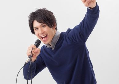 男性がマイクを手にもって楽しそうに歌っている様子