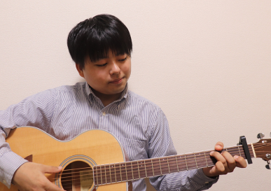 男性がギターを弾いている様子