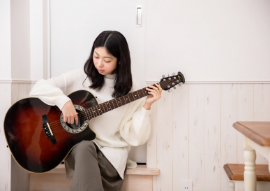 女性がギターを弾いている様子