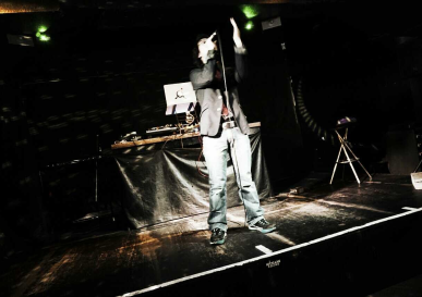 男性がステージで歌っている様子