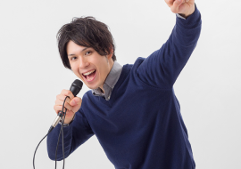 男性がマイクを手にもって楽しそうに歌っている様子